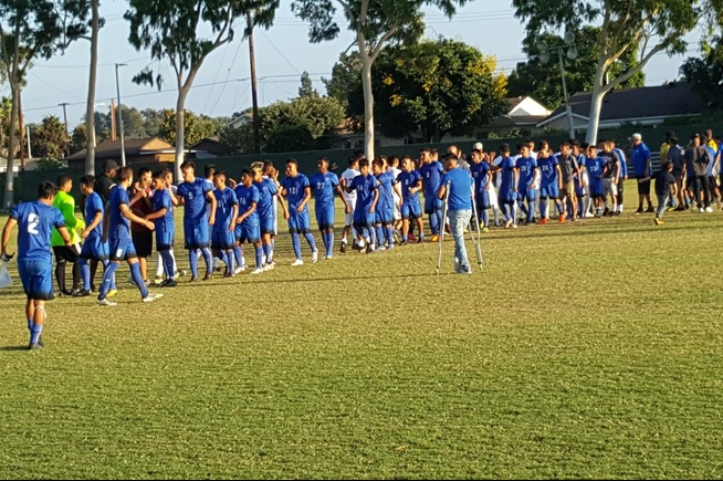 The men's soccer team celebrates their 1-0 win