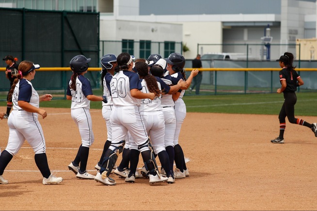 Teammates surround Richere Leduc (5) after her game-winning hit against Ventura